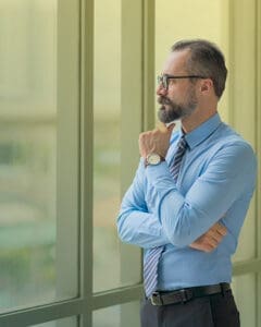 Christian Creative Business Man looking out window thinking